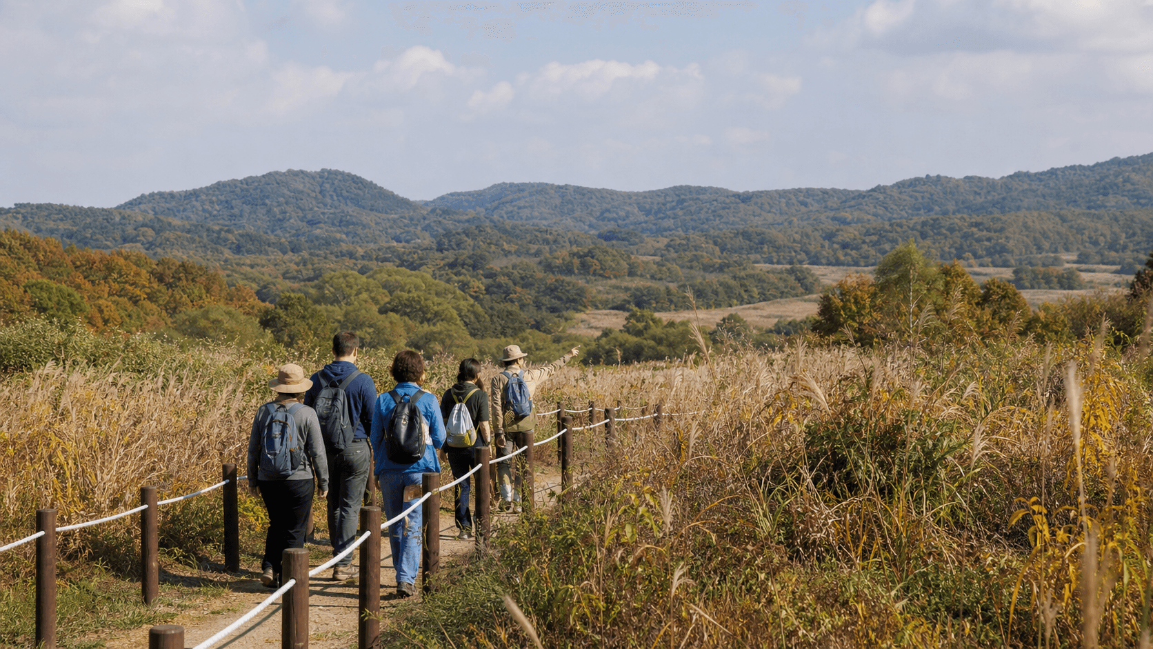 Illustrative small guided group walking on a public trail in a Korean border-region landscape